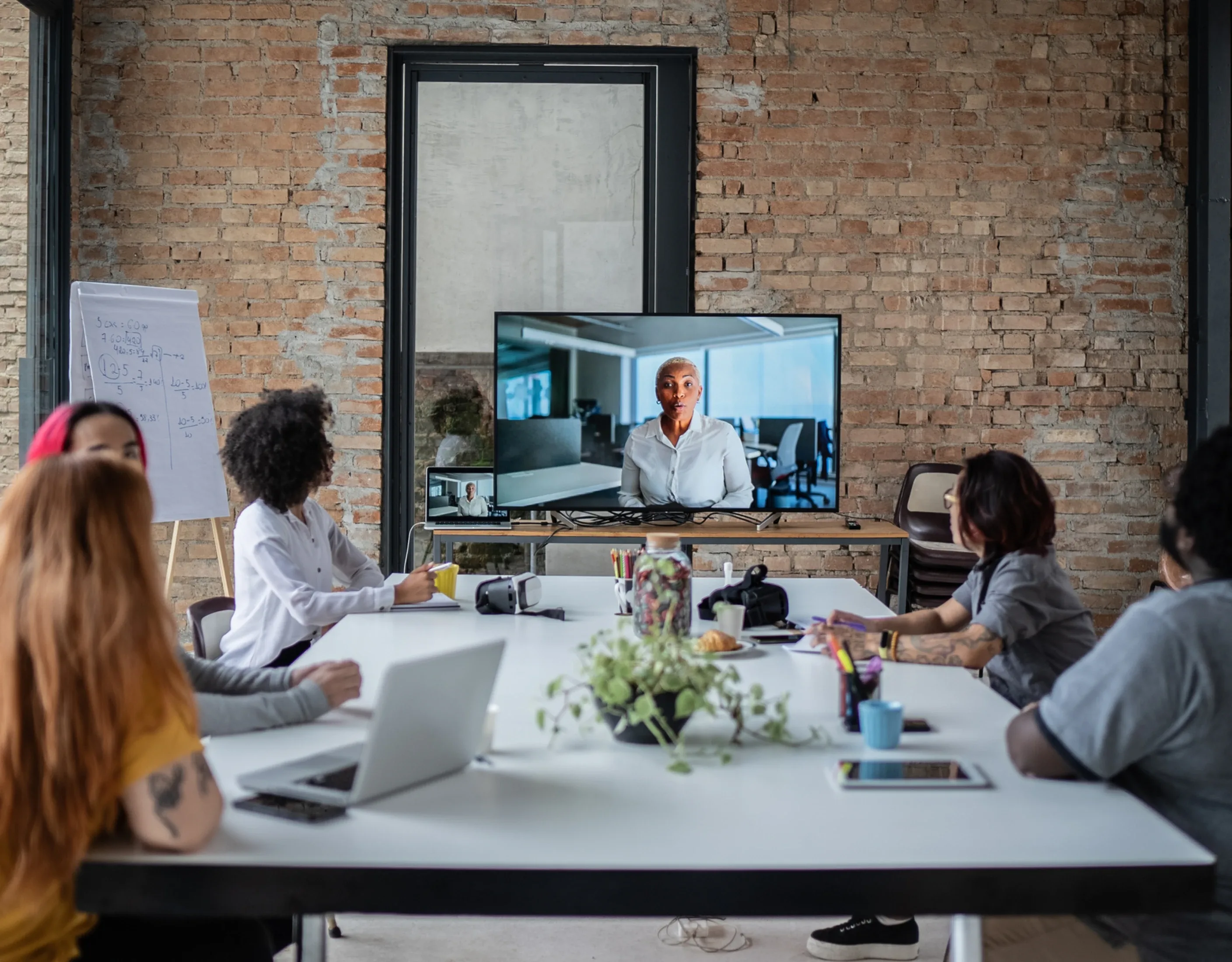 Group gathered around a table, participating in a virtual Qlik training session.